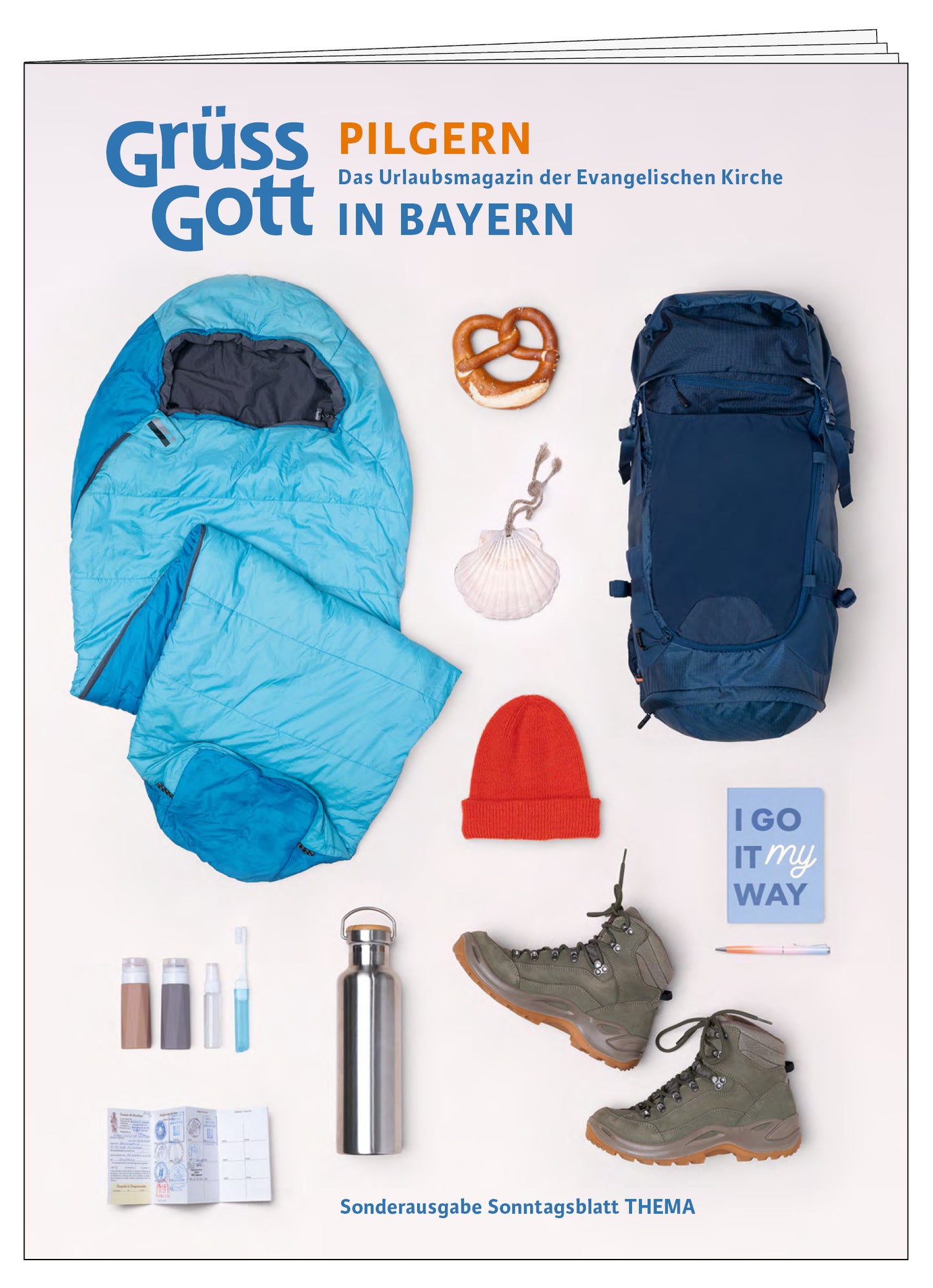 Cover der Sonderausgabe des THEMA-Magazins Grüß Gott. Pilgern in Bayern. Es zeigt einen blauen Schlafsack, Rucksack, Wasserflasche, Wanderschuhe und weitere Pilgerutensilien.