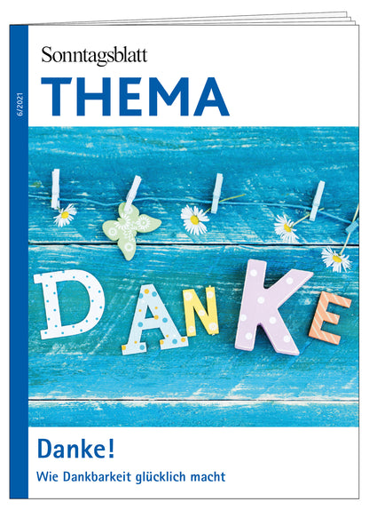 Cover des THEMA- Magazins 'DANKE! Wie Dankbarkeit glücklich macht. Das Bild zeigz bunte Buchstaben und Gänseblümchen an einer Wäscheleine vor blauem Holzhintergrund.