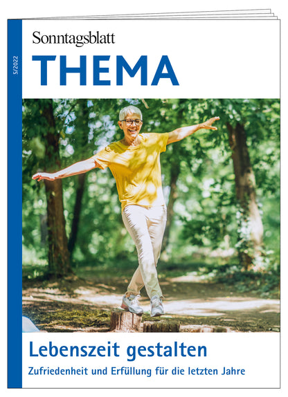 Cover des THEMA-Magazins Lebenszeit gestalten. Zufriedenheit und Erfüllung für die letzten Jahre. Eine ältere lachende Frau mit kurzen weißen Haaren, im  gelben Shirt balanciert auf kurzen Baumstümpfen im Wald. 